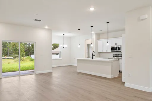 Open kitchen and living area with an island and pendant lights